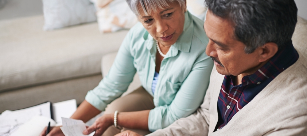 A photo of a middle-aged couple reviewing their finances together