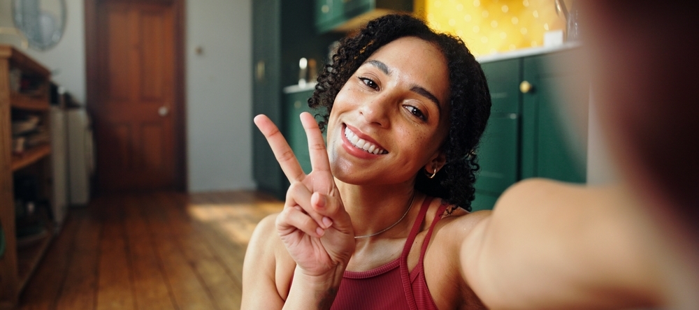 A photo of a woman taking a peace sign selfie