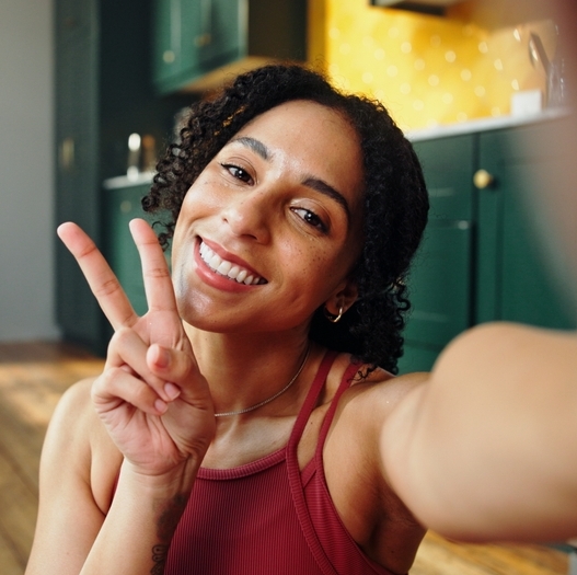 A photo of a woman taking a peace sign selfie