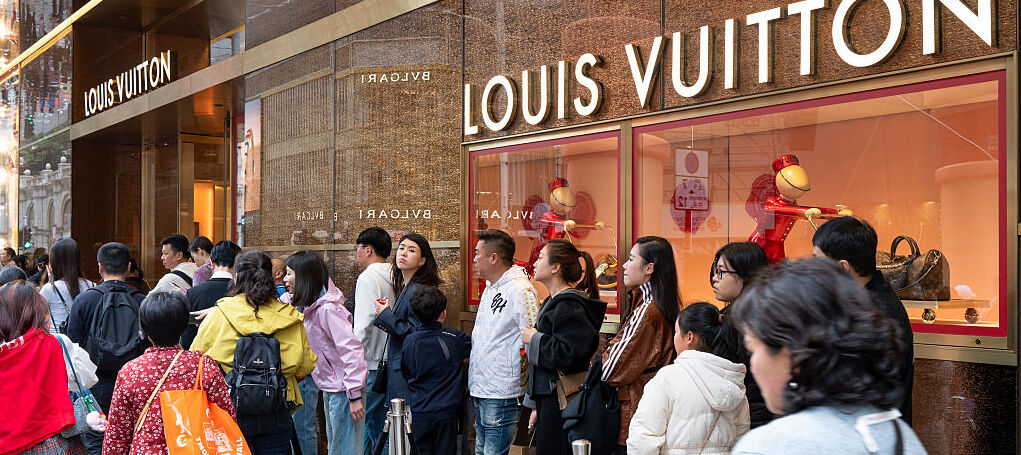 Shoppers seen queuing up as they wait to enter the French luxury fashion brand Louis Vuitton store.