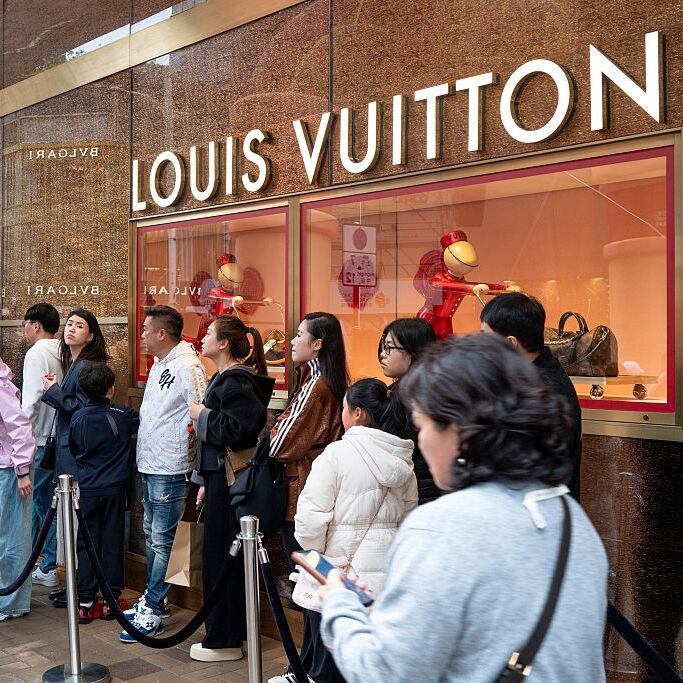 Shoppers seen queuing up as they wait to enter the French luxury fashion brand Louis Vuitton store.