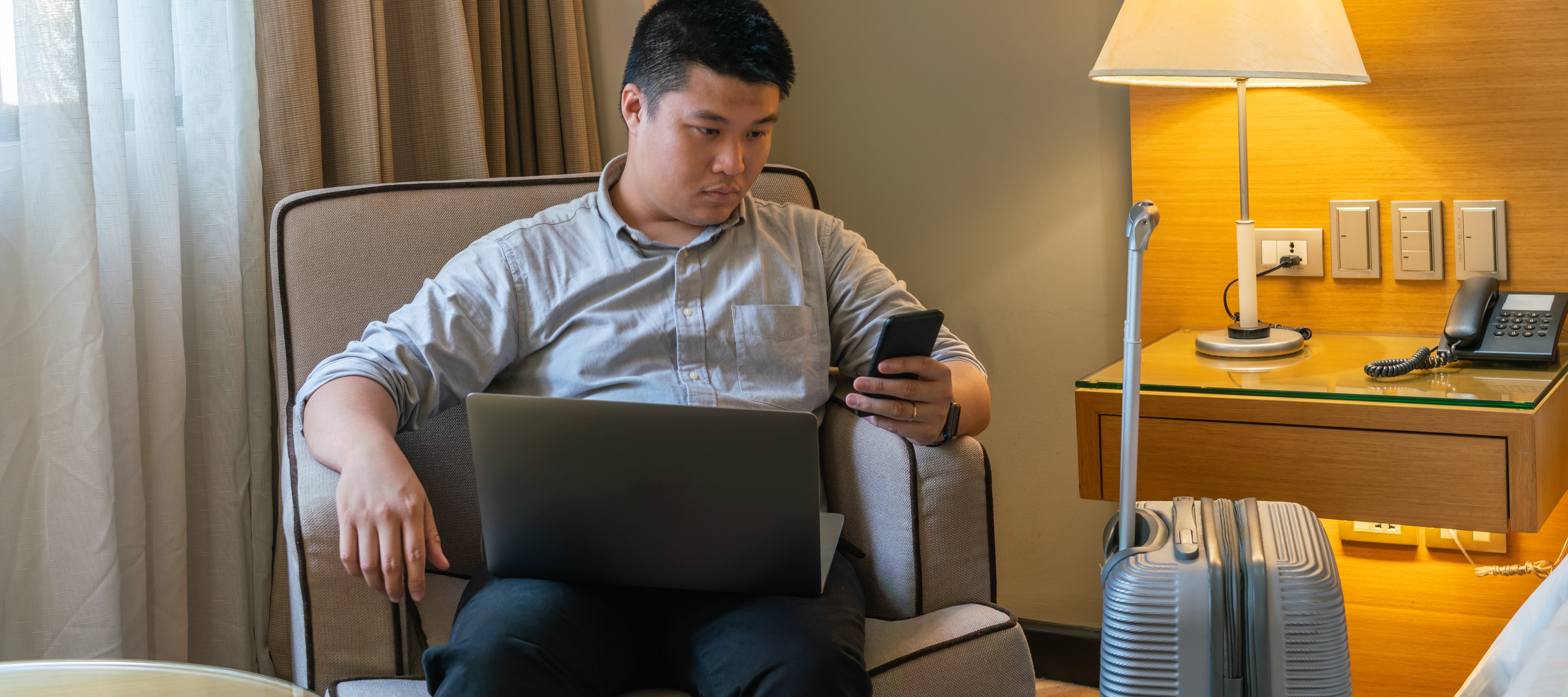 Man purchasing return flight on laptop in his hotel room