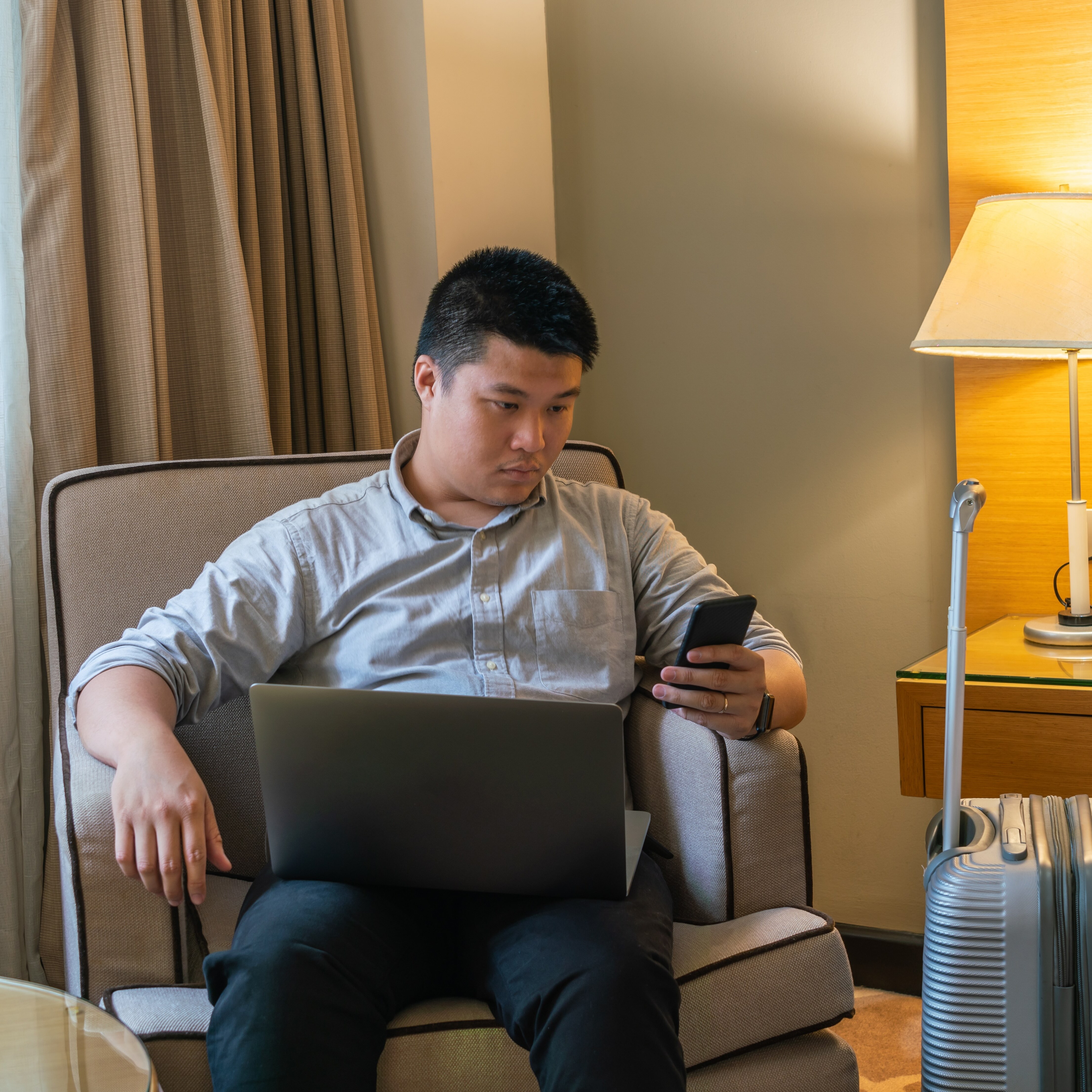 Man purchasing return flight on laptop in his hotel room