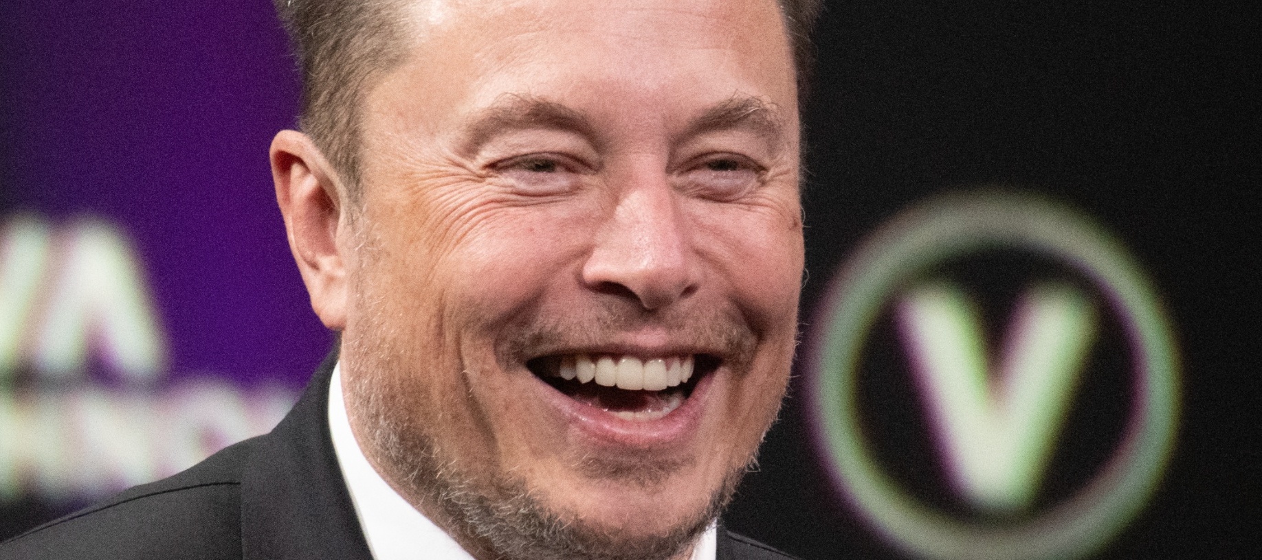 Elon Musk laughing on stage