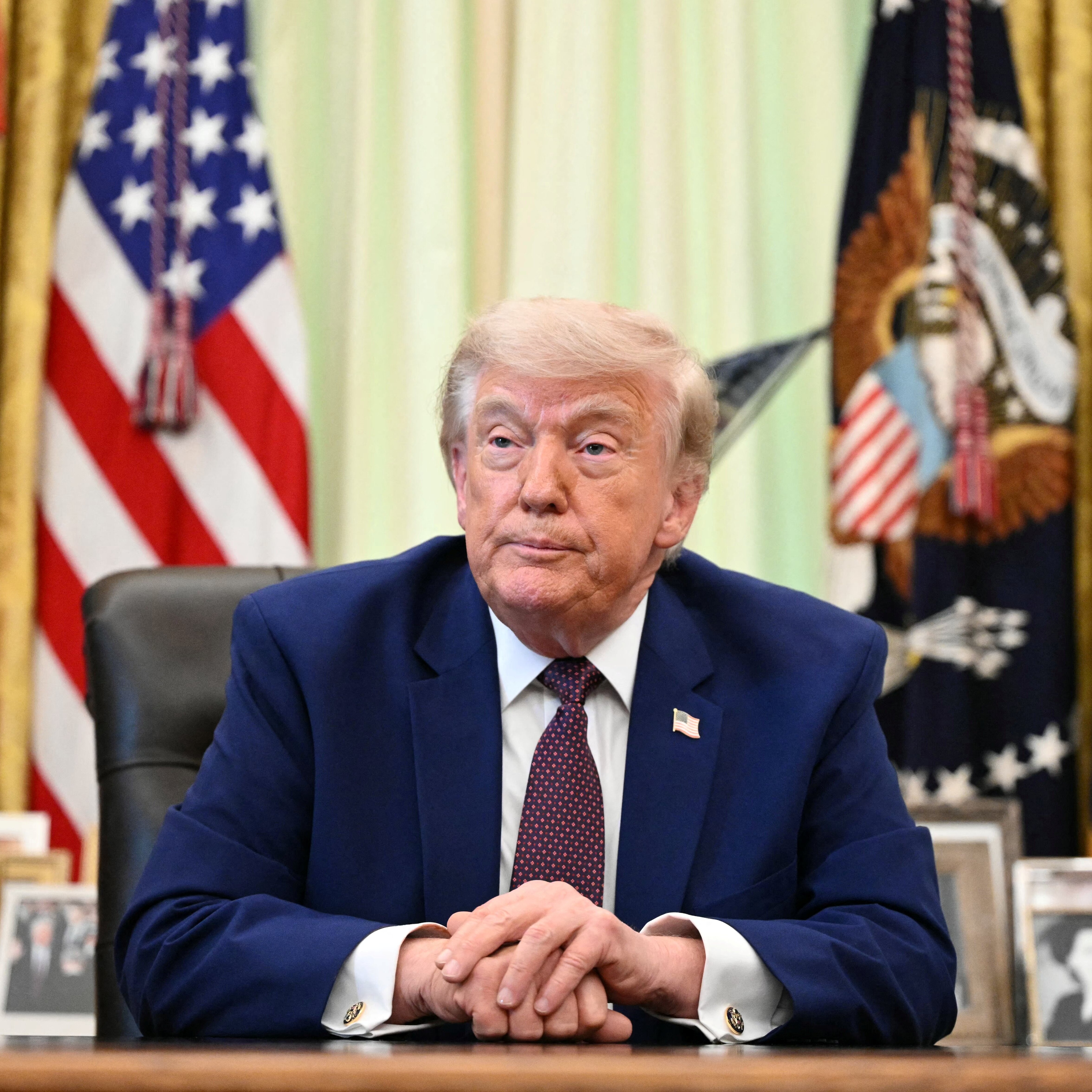 President Trump speaks to the press in the Oval Office of the White House.