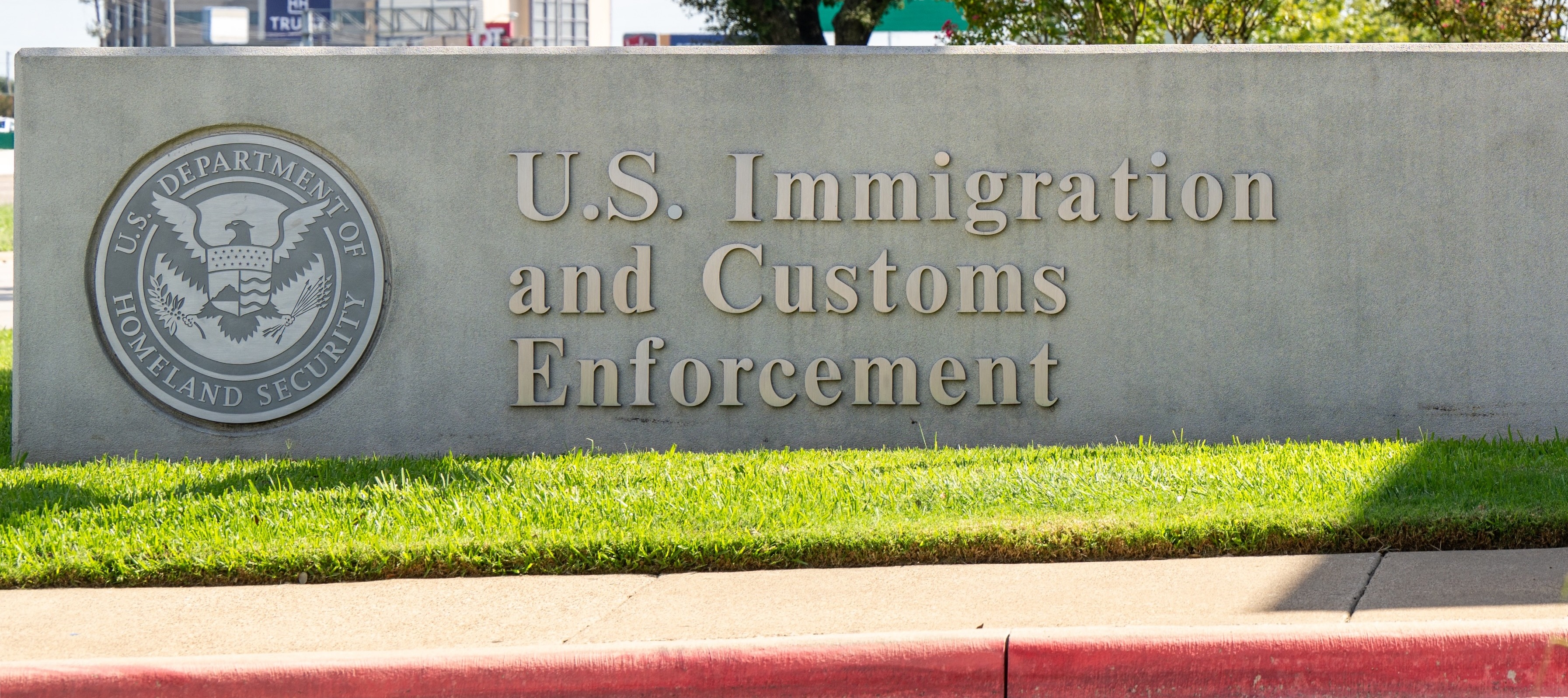 A short stone wall that reads "U.S. Immigration and Customs Enforcement."