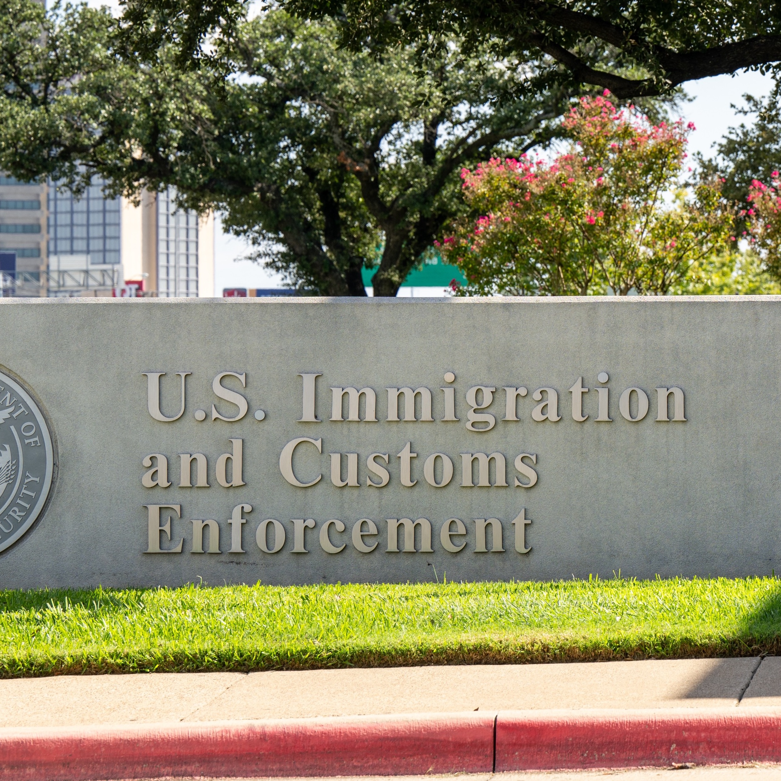 A short stone wall that reads "U.S. Immigration and Customs Enforcement."