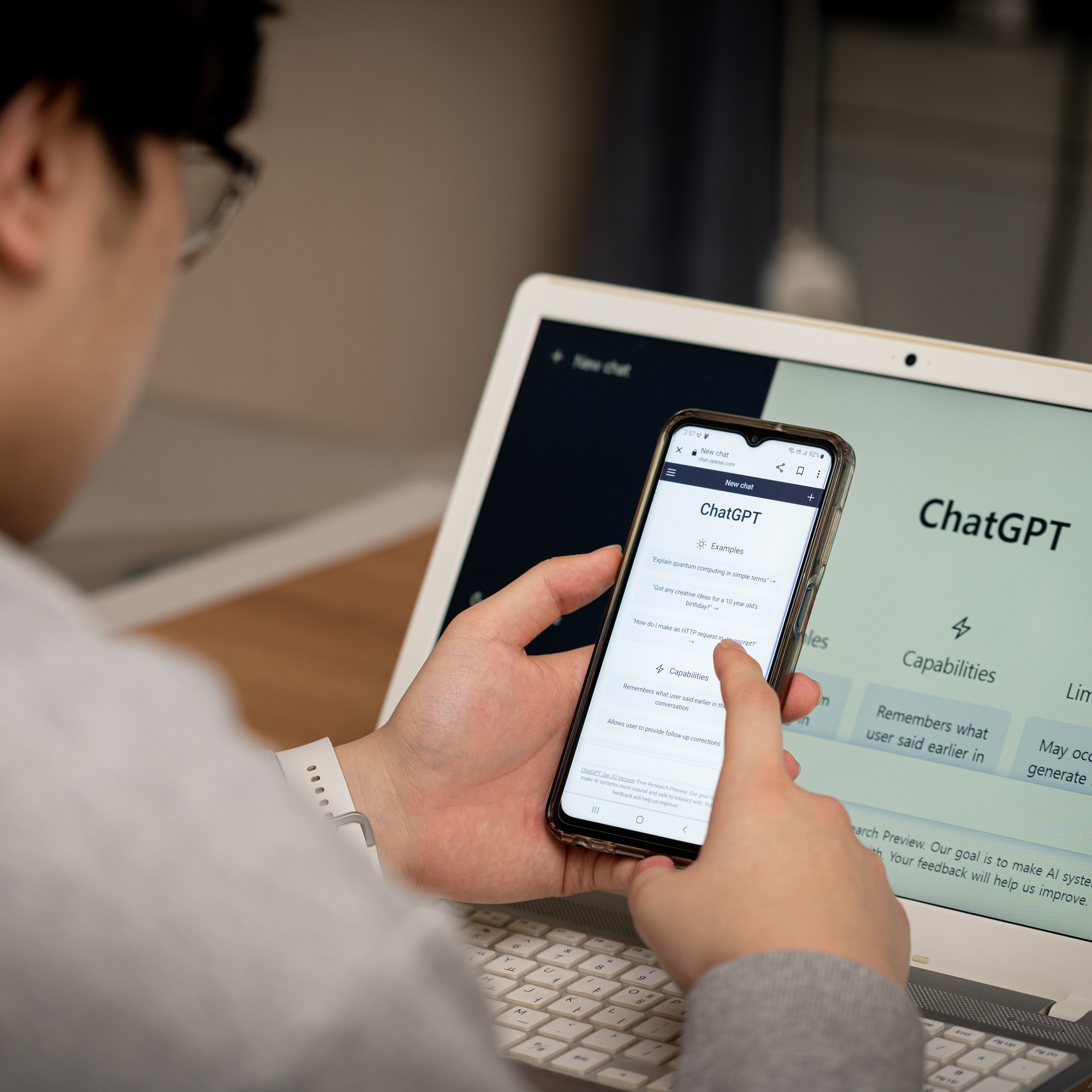 A man using ChatGPT on both his computer and his mobile phone.