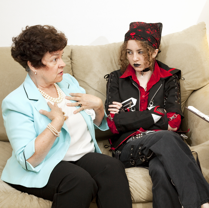 Photo of young adult with parents, looking annoyed