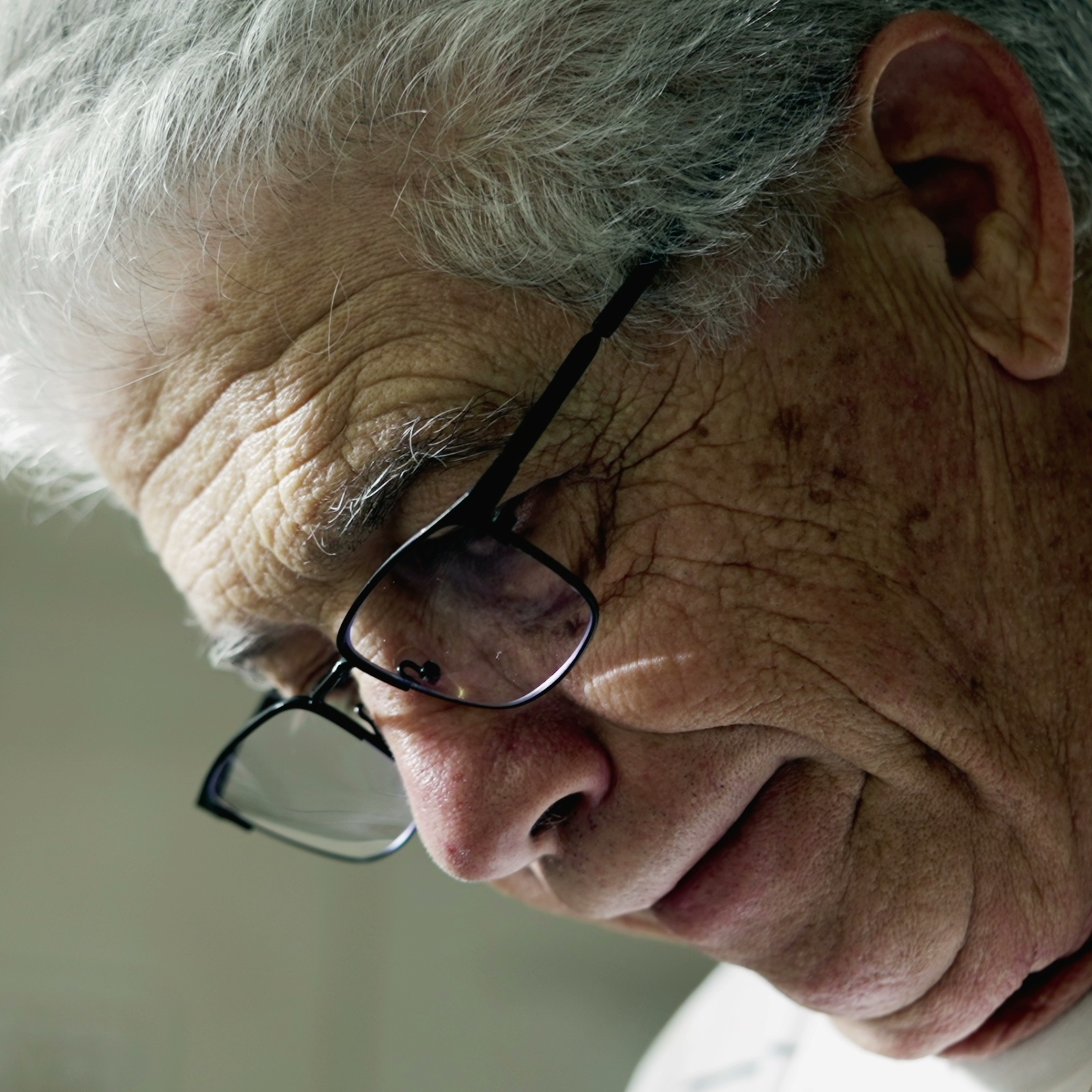 An old man looking down, sad
