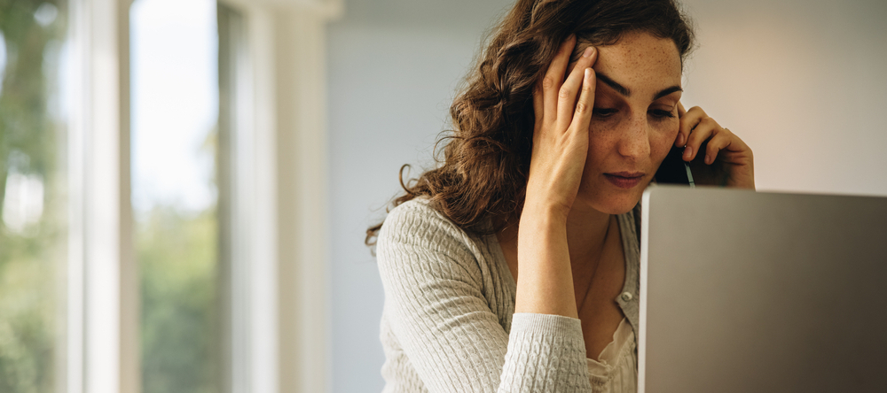 A photo of a woman on the phone stressed
