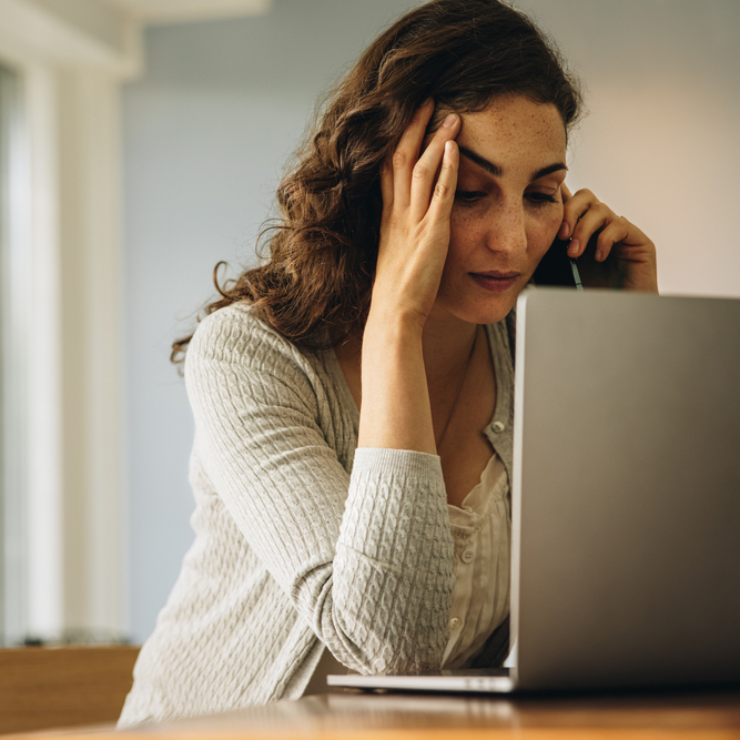 A photo of a woman on the phone stressed