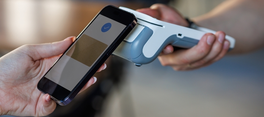 A photo of someone using tap-to-pay with a smartphone