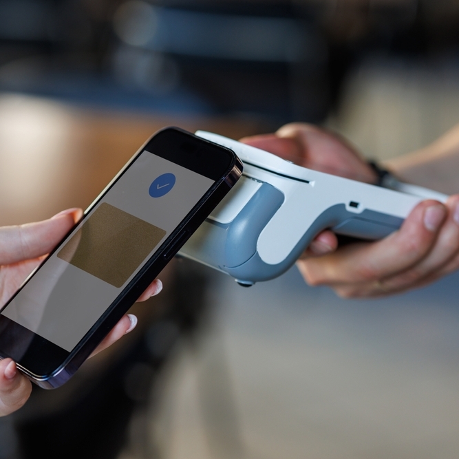 A photo of someone using tap-to-pay with a smartphone