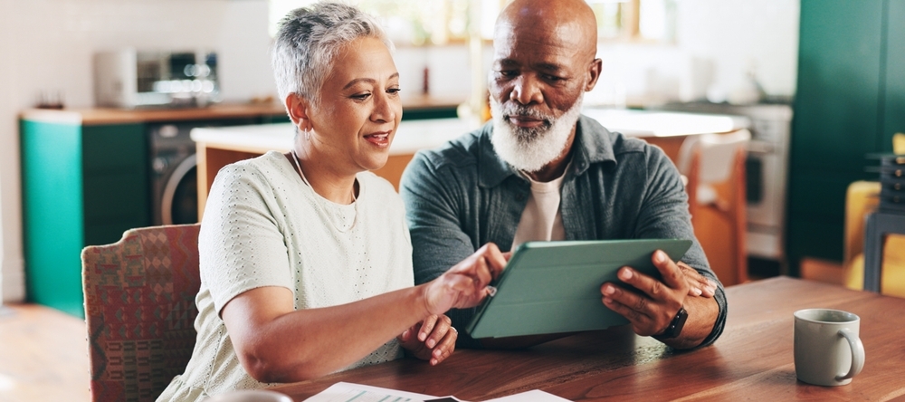 A photo of a couple reviewing financial documents on an iPad