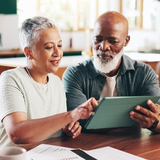 A photo of a couple reviewing financial documents on an iPad