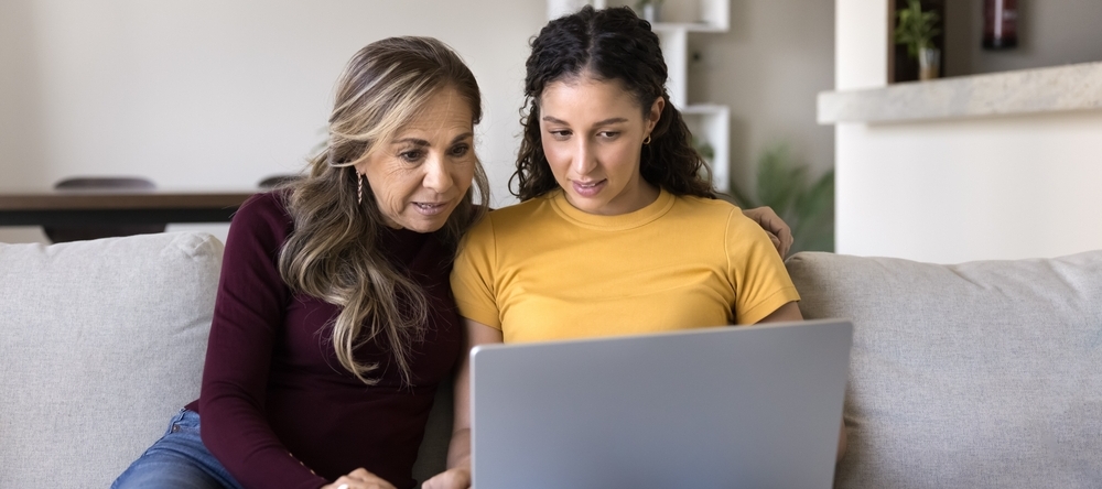 A daughter and a mother looking at a laptop