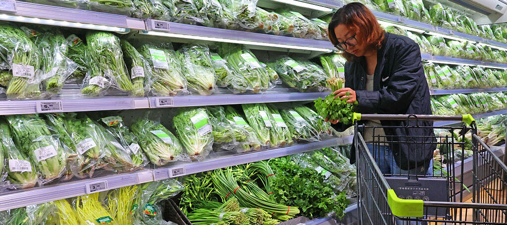 A consumer purchases vegetables at a supermarket.