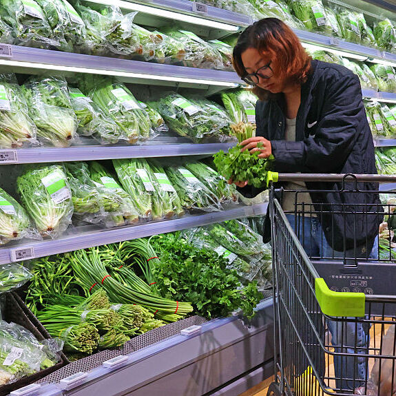 A consumer purchases vegetables at a supermarket.