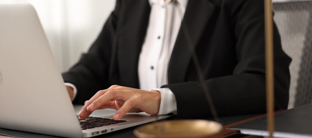 A photo of a court reporter typing on a laptop
