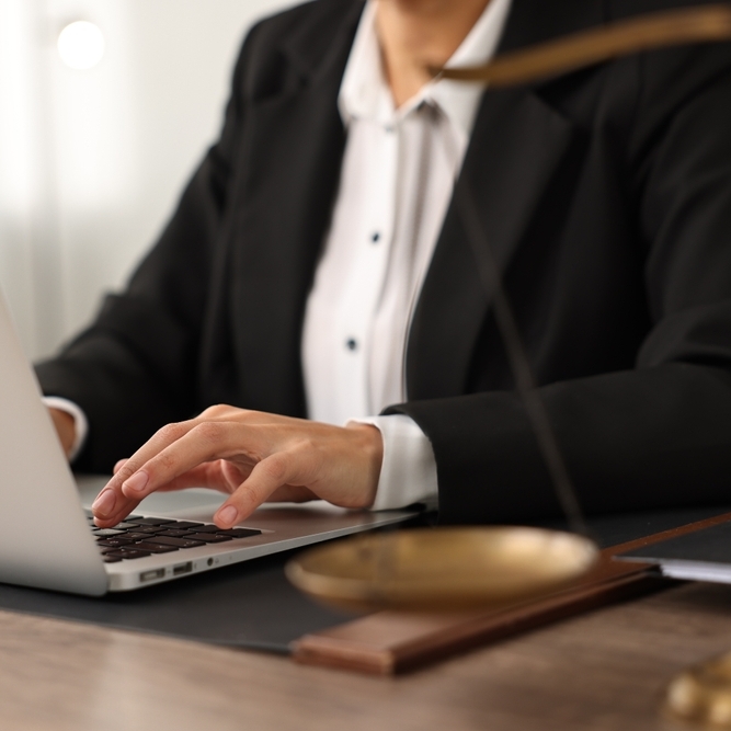 A photo of a court reporter typing on a laptop