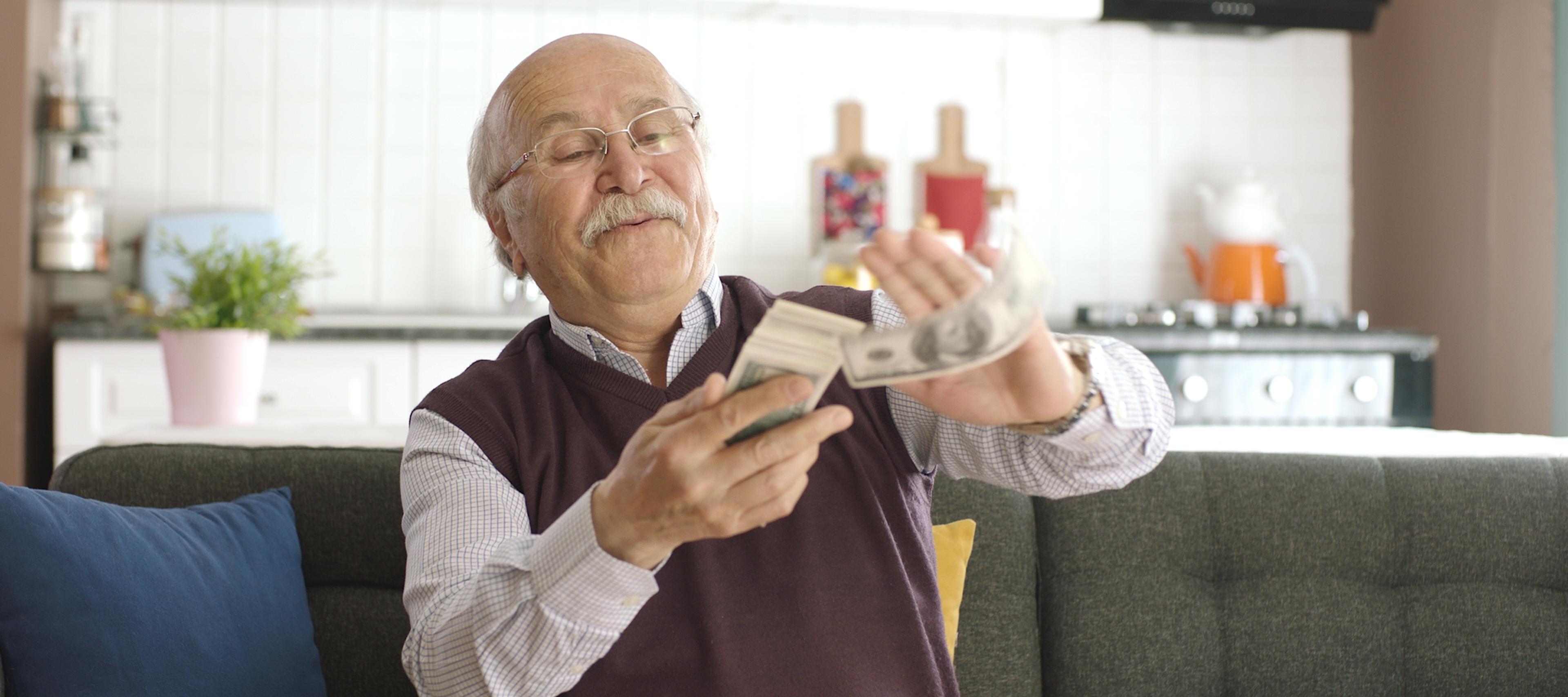An older man attempts to make it rain with money.