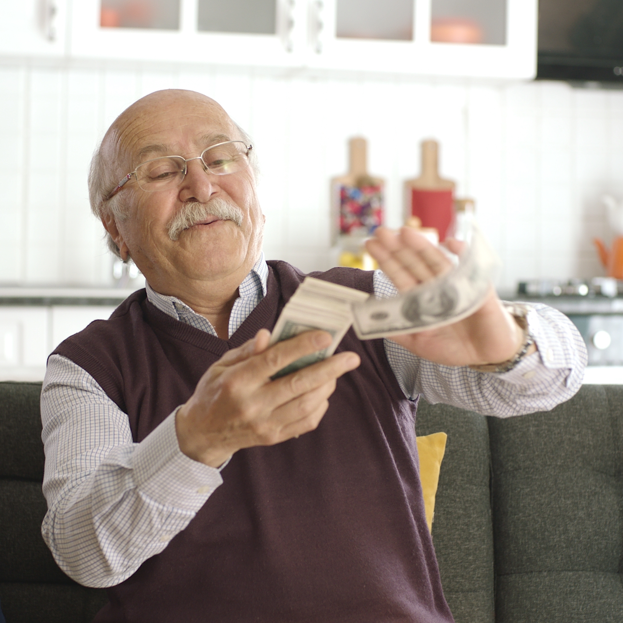 An older man attempts to make it rain with money.