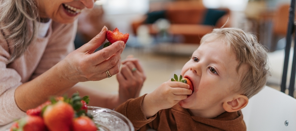 Young child eating strawberries.