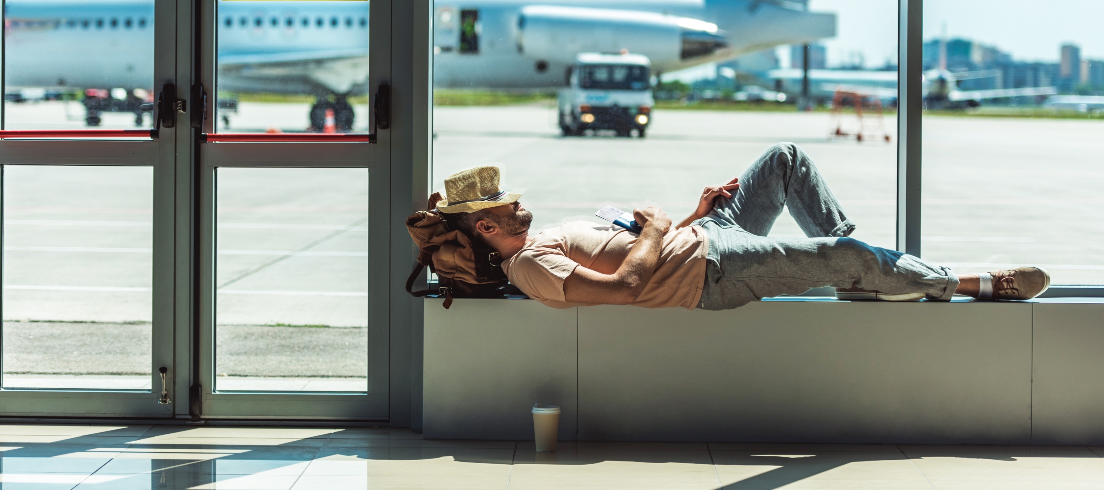 Man seen lounging at airport gate, seeming very relaxed and unbothered.
