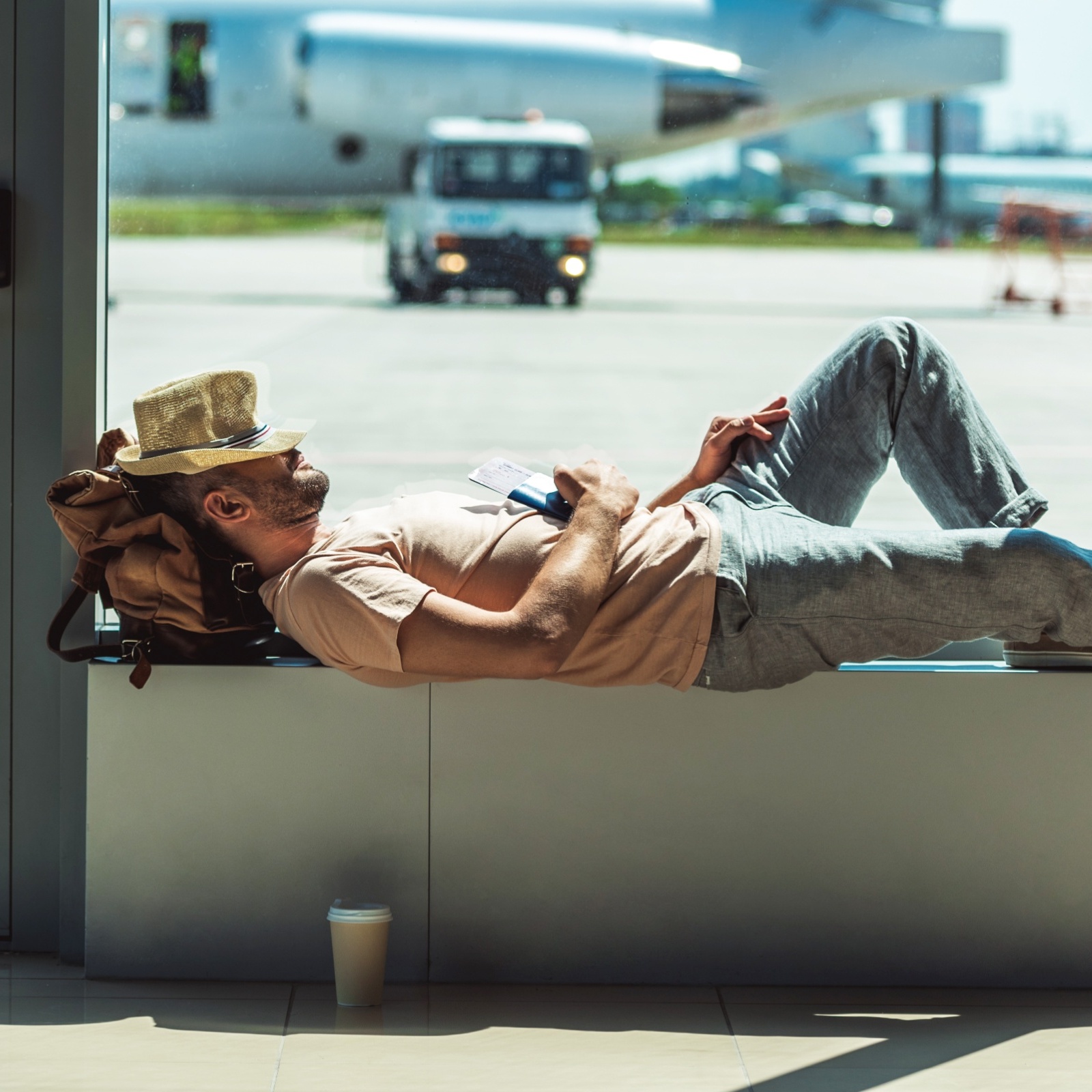 Man seen lounging at airport gate, seeming very relaxed and unbothered.