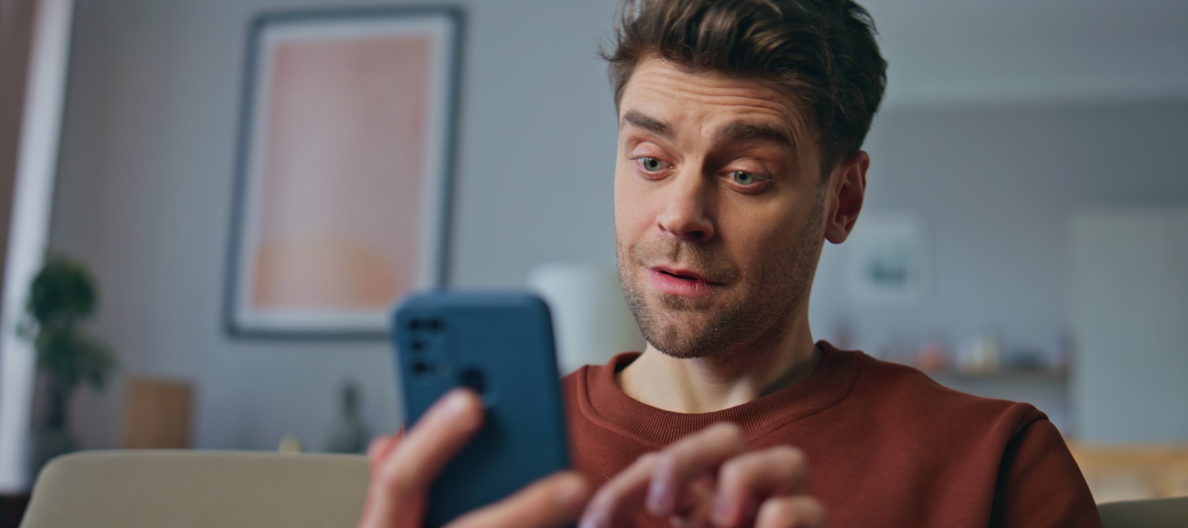 man looking amused by phone