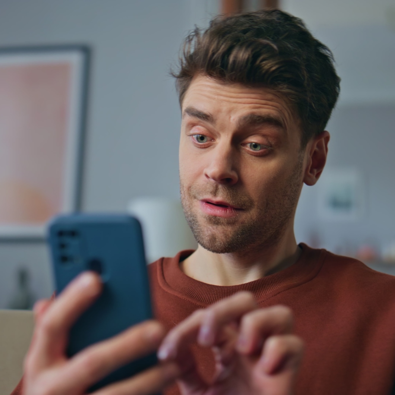 man looking amused by phone