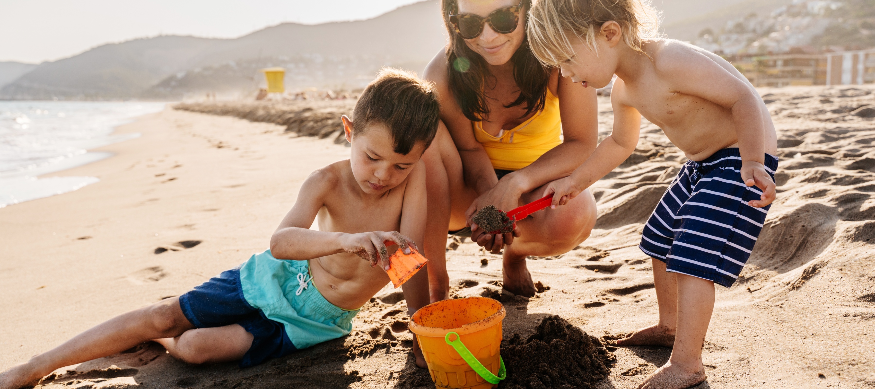 Family playing with sand on the beach