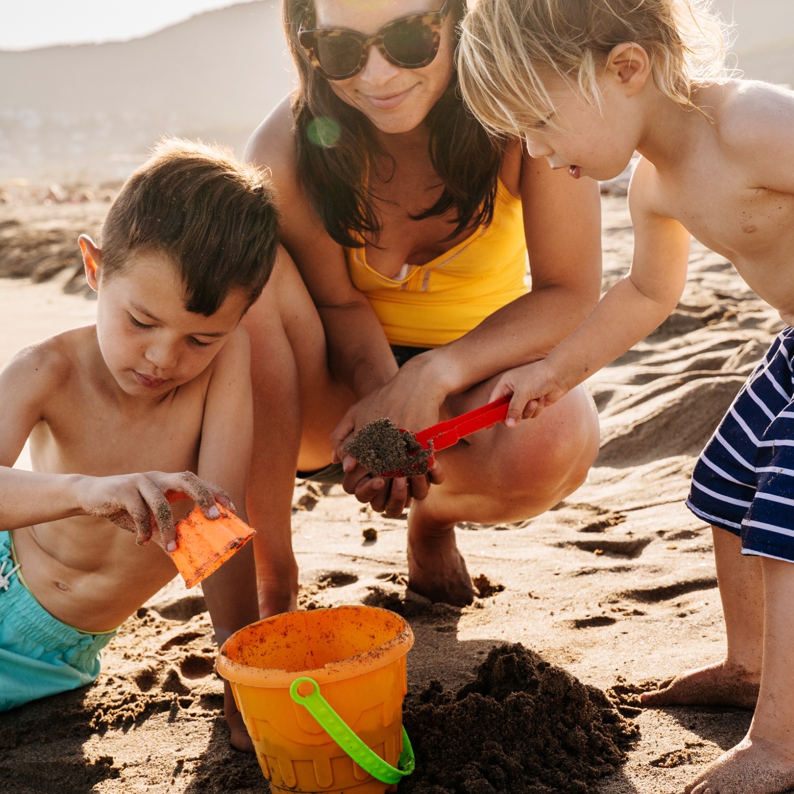 Family playing with sand on the beach