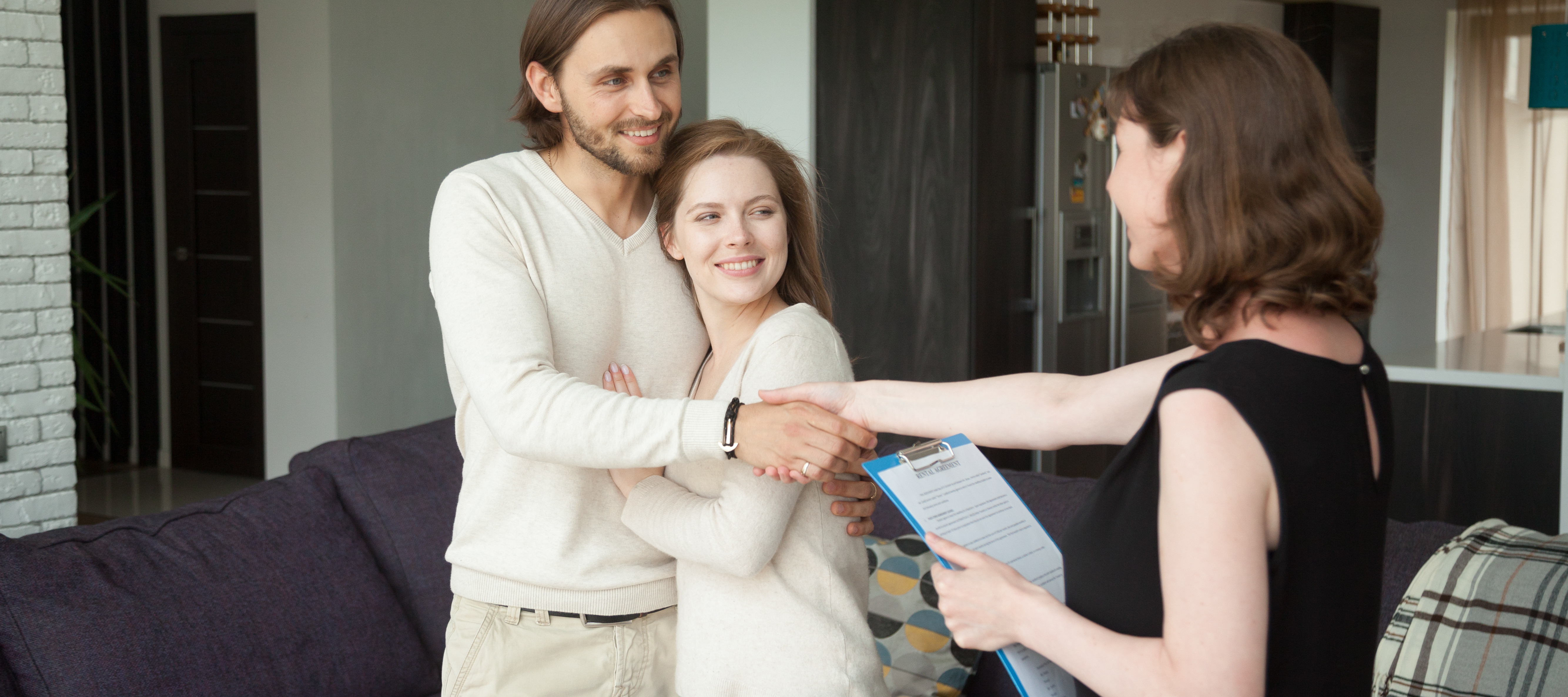 A landlord showing a home to a young couple.