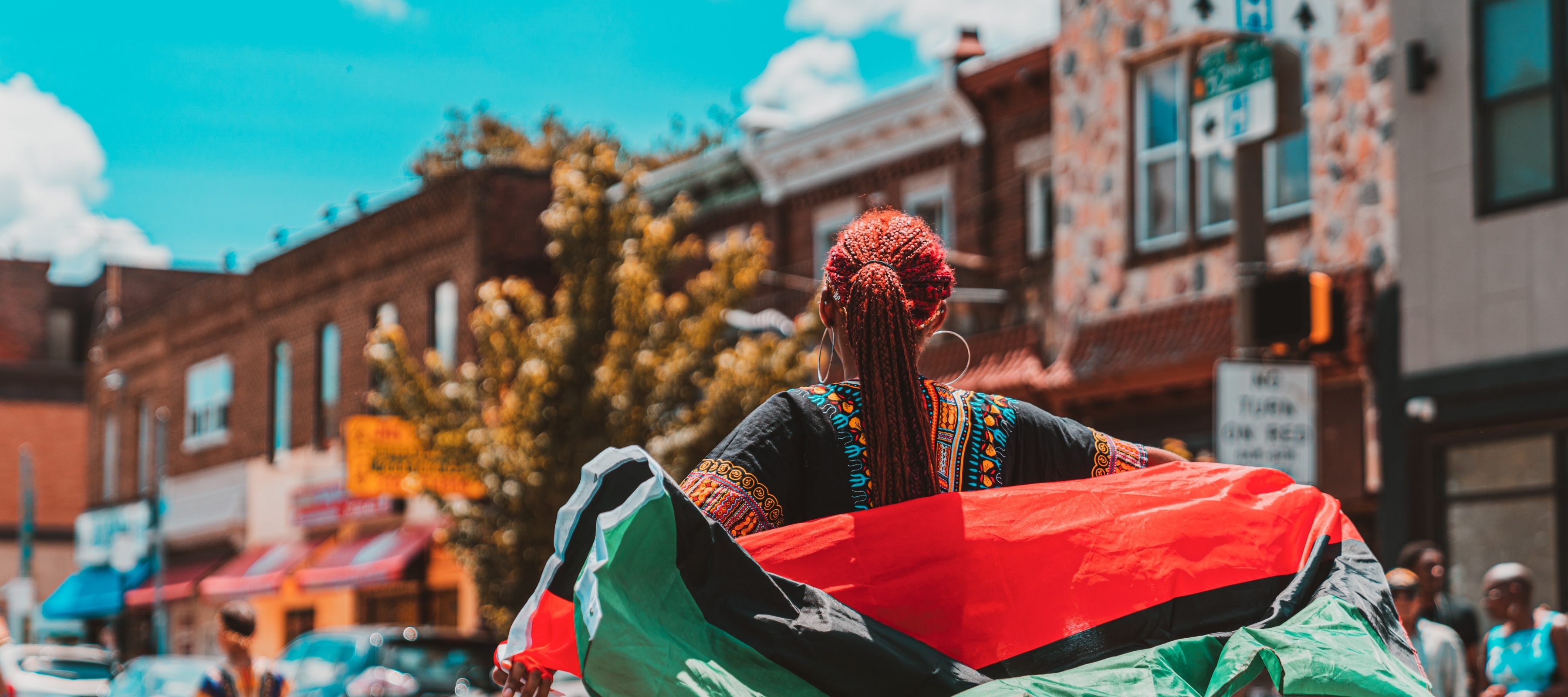 A Black woman wearing an African flag during a Juneteenth parade in Philadelphia