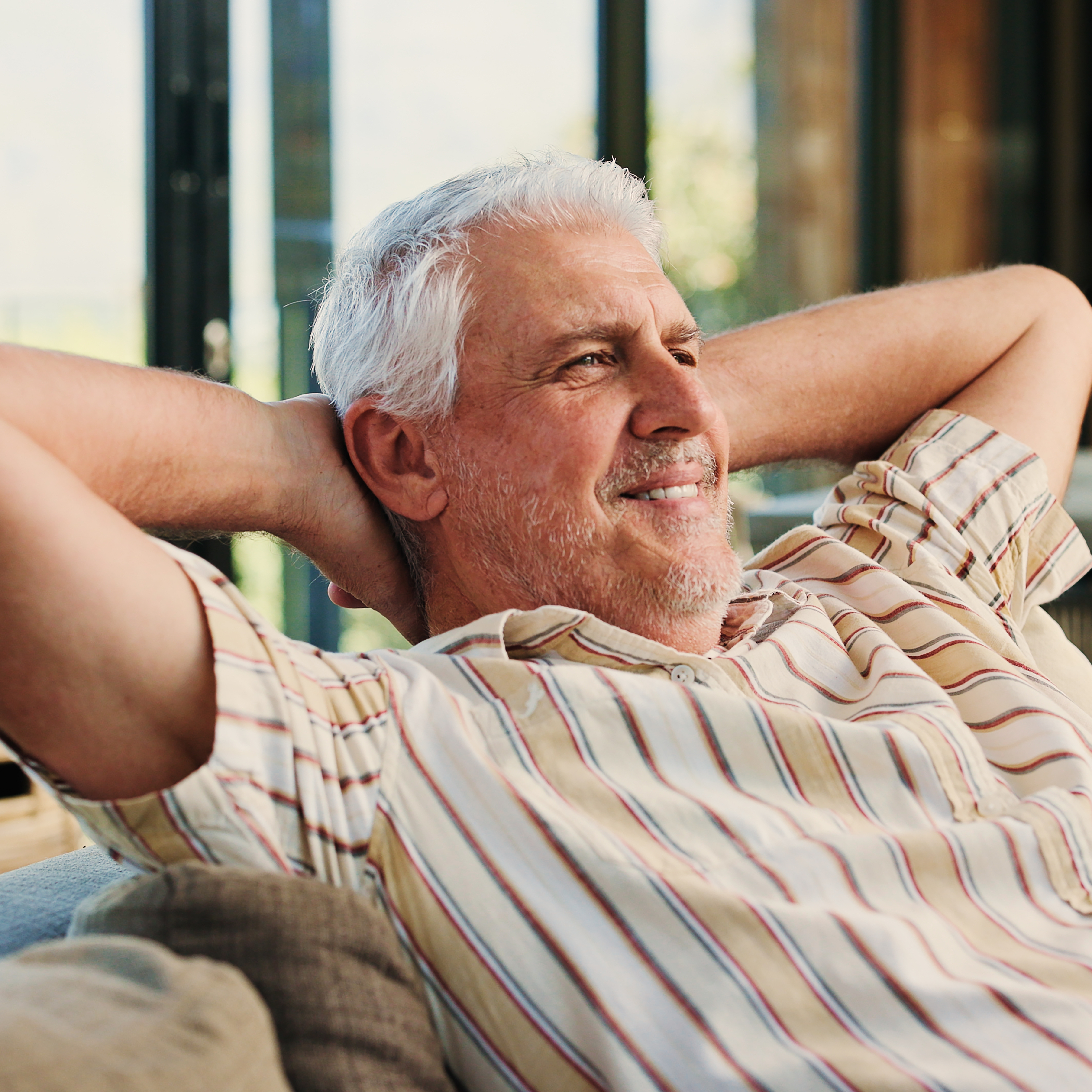 An older man relaxing on the couch.