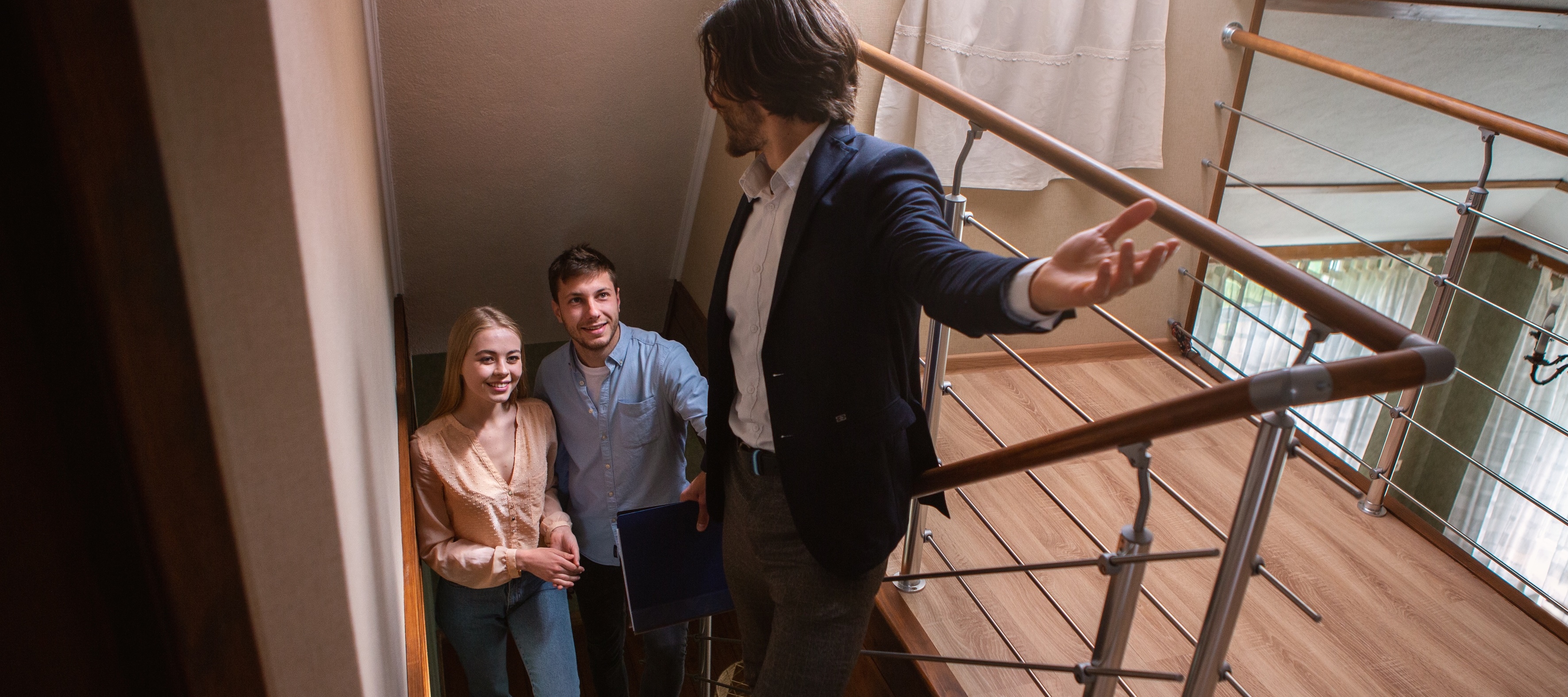 A man showing a house to a couple
