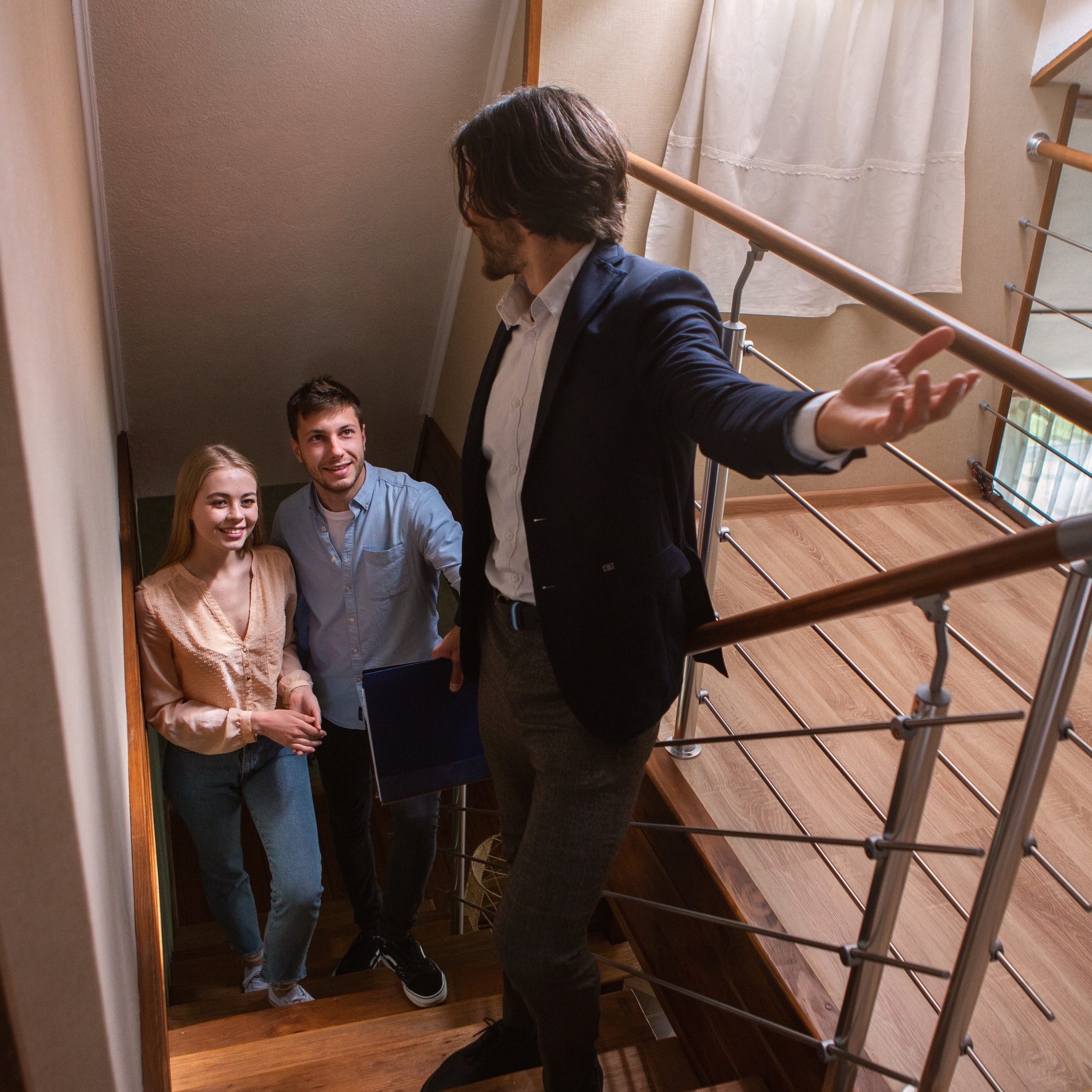 A man showing a house to a couple