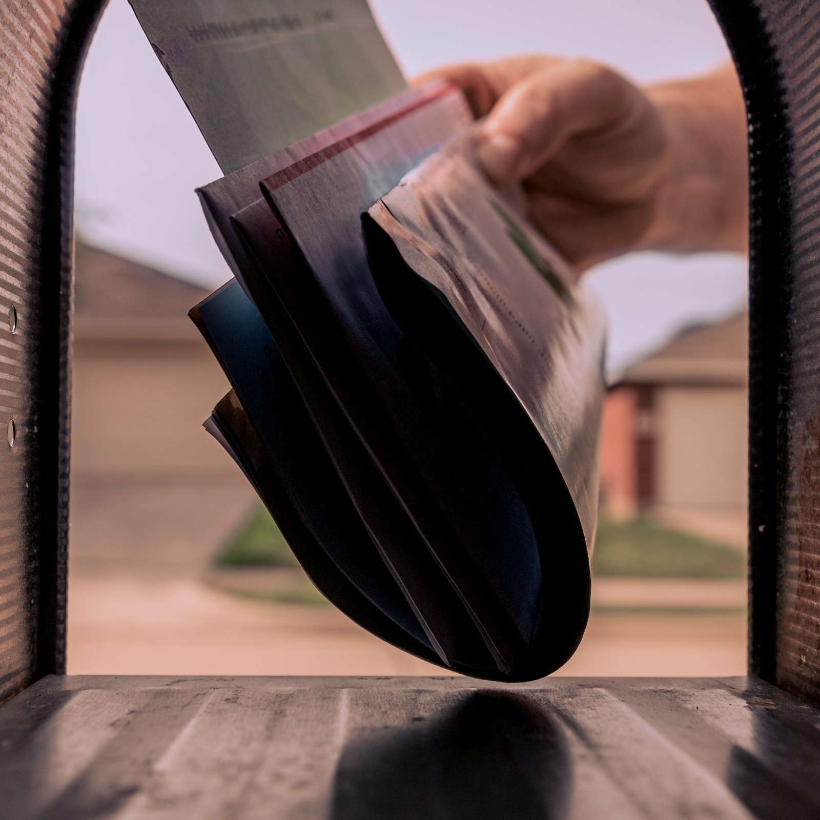 A hand getting mail out of their mailbox.