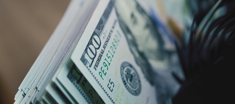 Cash counting machine counts hundred dollar bills.