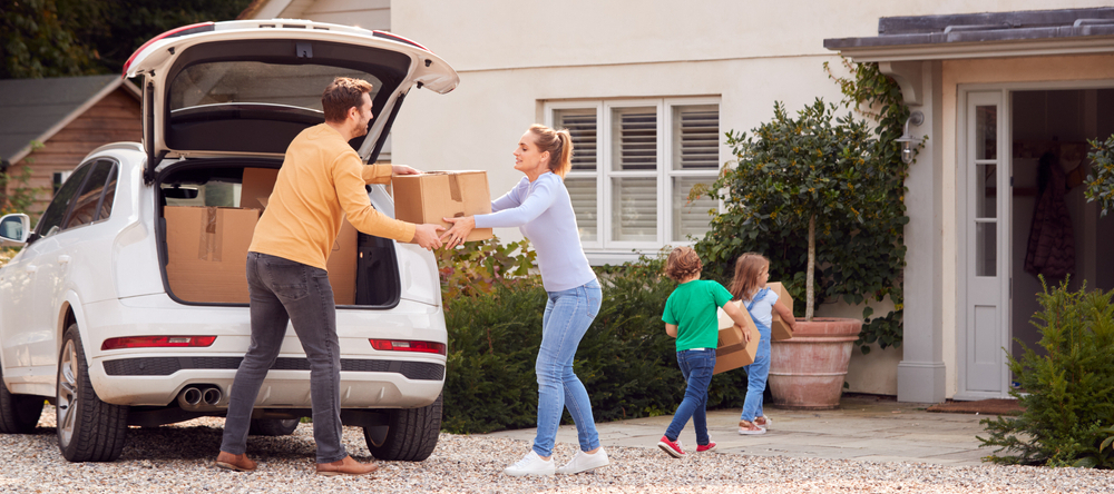 A photo of a family moving boxes into a new home