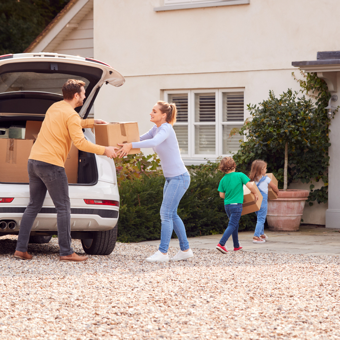 A photo of a family moving boxes into a new home