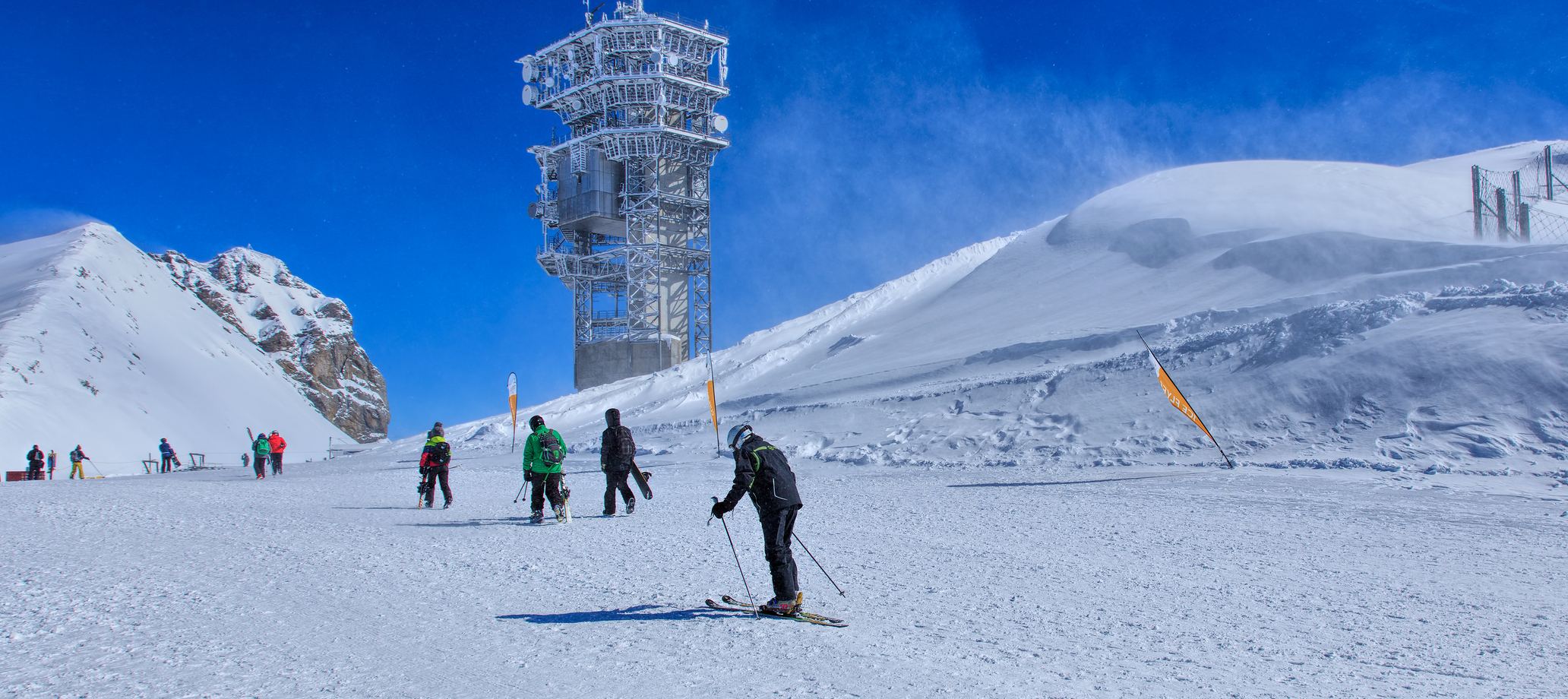People on the top of Mt. Titlis on a windy day. Mt. Titlis is located on the border between the Swiss Cantons of Obwalden and Bern.