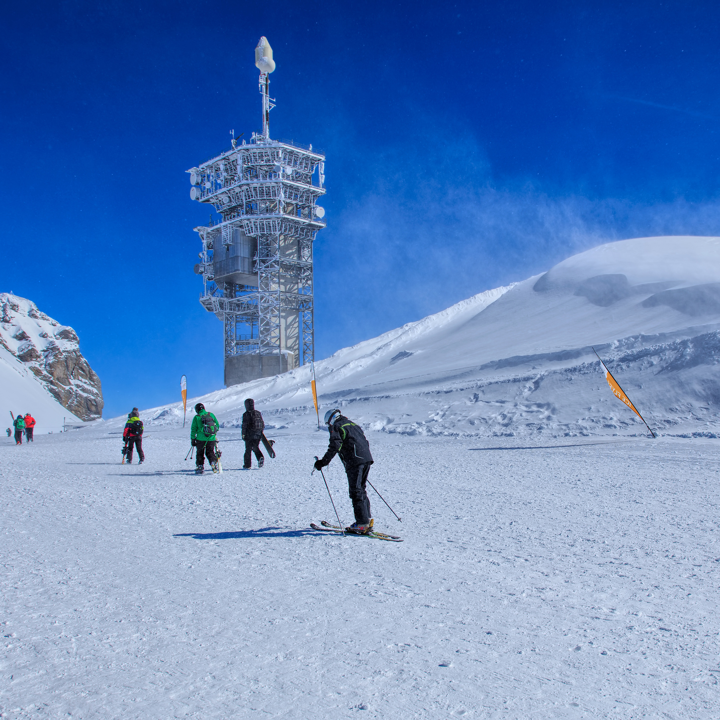 People on the top of Mt. Titlis on a windy day. Mt. Titlis is located on the border between the Swiss Cantons of Obwalden and Bern.