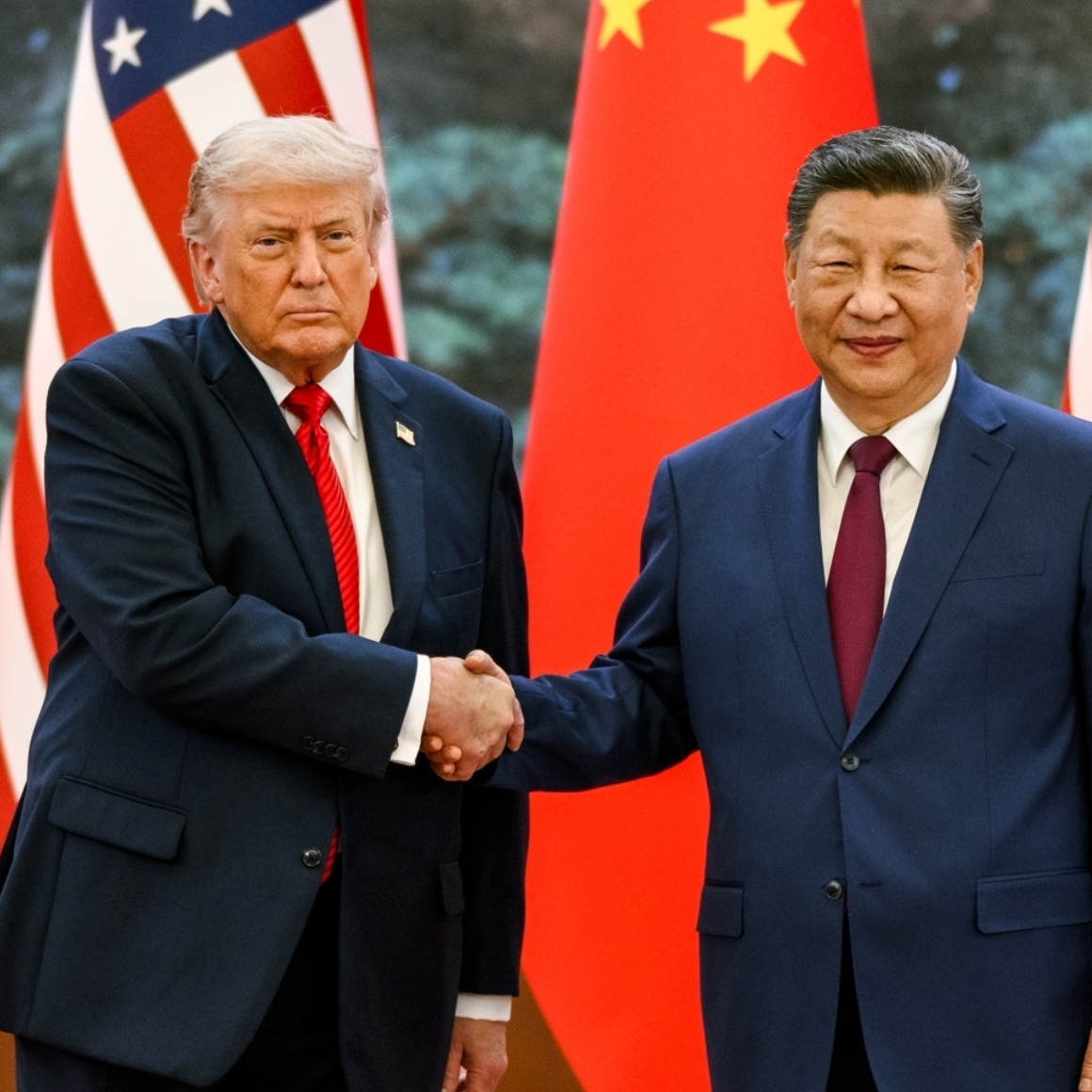 Xi Jinping and Donald Trump shake hands in front of their countries' flags