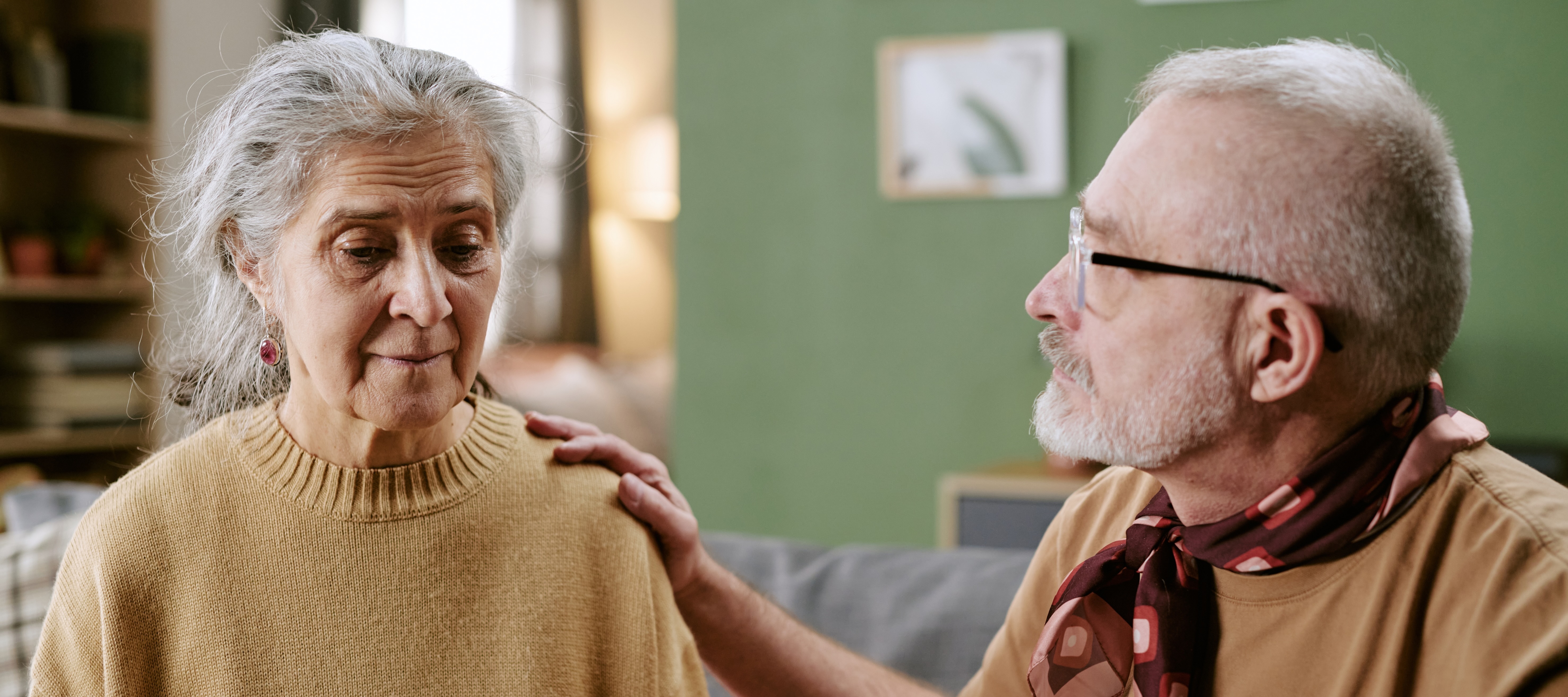 older woman comforted by an older man