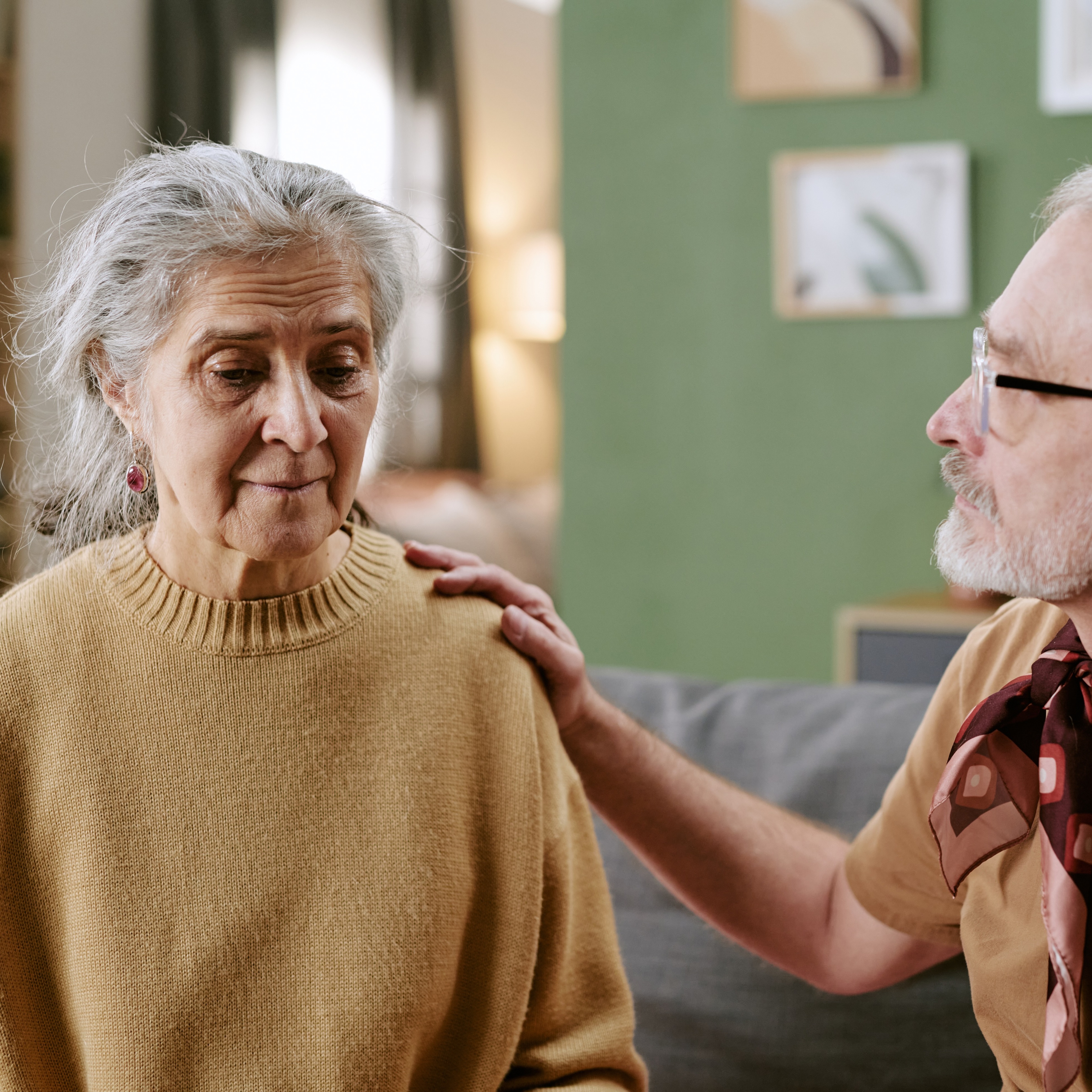 older woman comforted by an older man