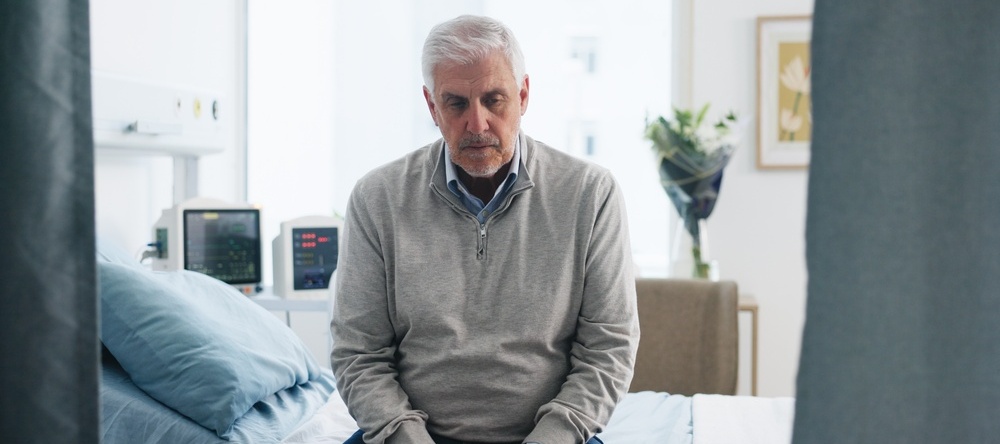 Worried man sitting on his bed.