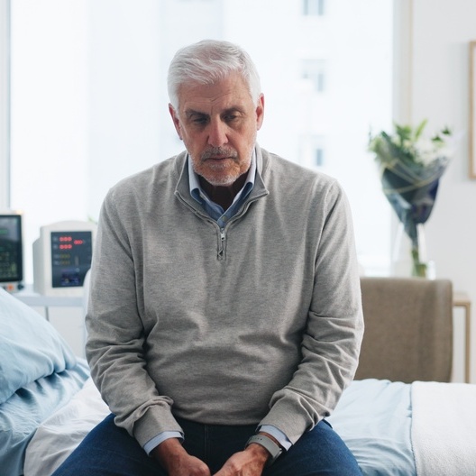 Worried man sitting on his bed.